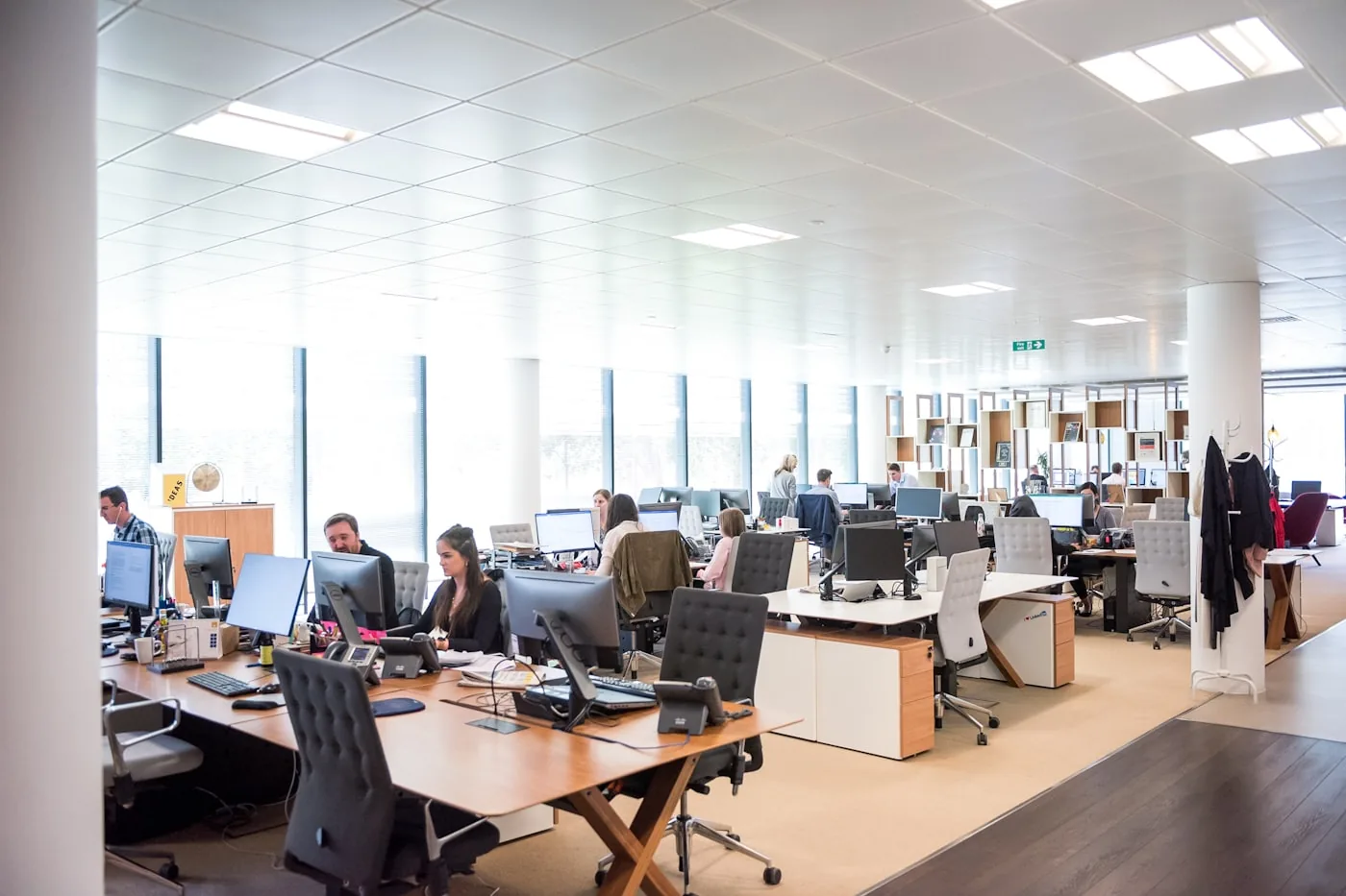 Bureau ouvert lumineux, plusieurs personnes à leur poste de travail